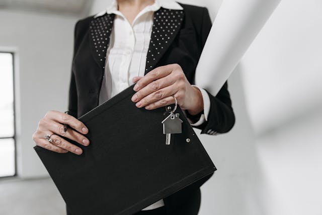 a real estate agent holding a folder and a set of house key